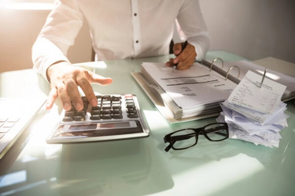 close up of a businessman's hand calculating bill in office