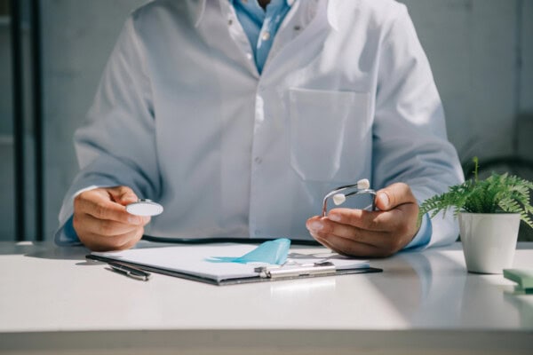 depositphotos 310723650 stock photo cropped view doctor sitting desk